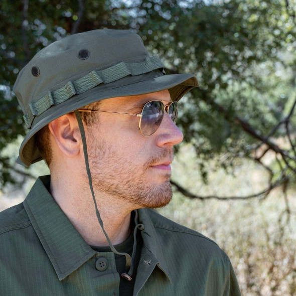 Man outside wearing the U.S. Made Vietnam Jungle Hat, Shooter Brim in the color olive looking to the left Man outside wearing the U.S. Made Vietnam Jungle Hat, Shooter Brim in the color olive looking to the left