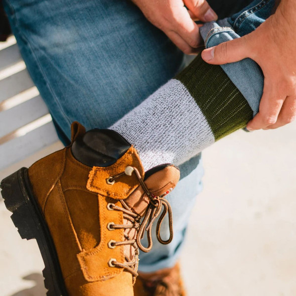 Model with legs crossed wearing the olive Mid-calf socks