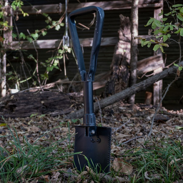 The U.S. Issue AMES Tri-fold Shovel in the ground unfolded