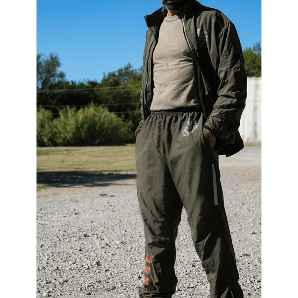 Man outside standing on a road with his hands in his pocket wearing the USMC Official Physical Training Running Pant