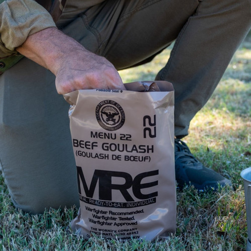 opening a mre meal in a field 