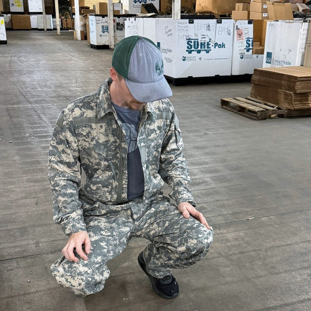 man kneeling with the full main zipper open and a tee shrit Military Issue Mechanics Coveralls, UCP/ACU