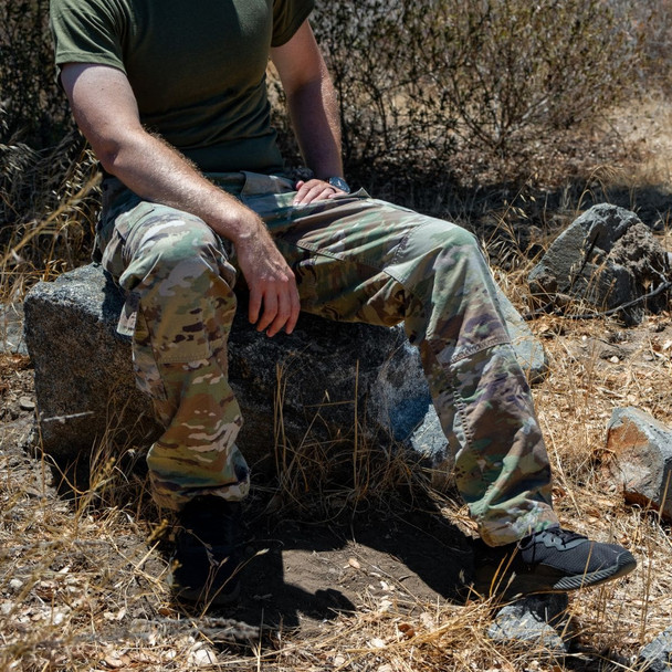 Man sitting on a rock wearing the U.S. Issue OCP Uniform Pant with his hands on his legs 