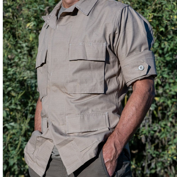 Man in tan bdu rip-stop cotton shirt jacket featuring four front cargo pockets and reinforced elbows with sleeves rolled up