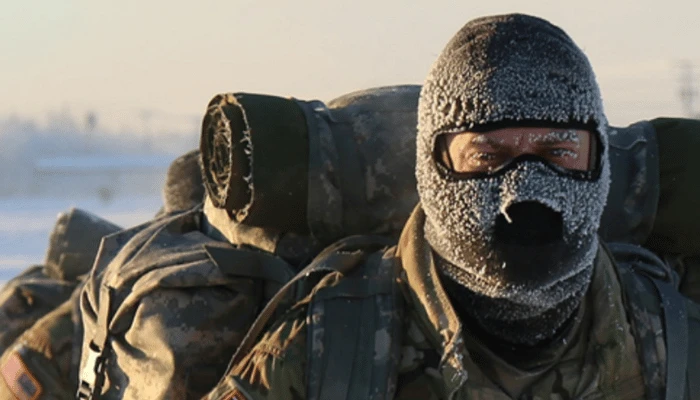 Person in a balaclava and cold weather layers in freezing conditions