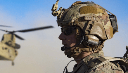 soldier with a helmet and helicopter in the background 