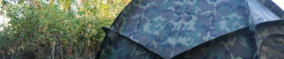 camo tent set up in the trees or field