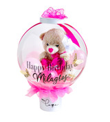 Birthday teddy bear stuffed in a clear bubble balloon.