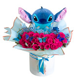 A Stitch Plush surrounded by roses  in a white floral box.