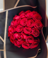 24 red roses bouquet in a black paper wrapping.