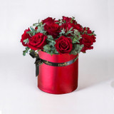 A dozen of red roses and red box in a white backdrop