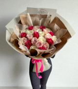 A bouquet of hot pink, pink and white roses, wrapped with Kraft Luxury Paper hold by a person against a white backdrop.