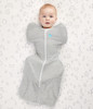 Grey Love To Dream swaddle on baby, arms up design, white trim, tight in the middle with wider hips for healthier swaddling