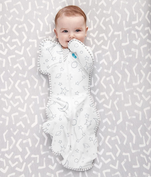 Cream Stars Love To Dream swaddle on sleeping baby, arms up design, white trim, tight in the middle with wider hips for healthier swaddling