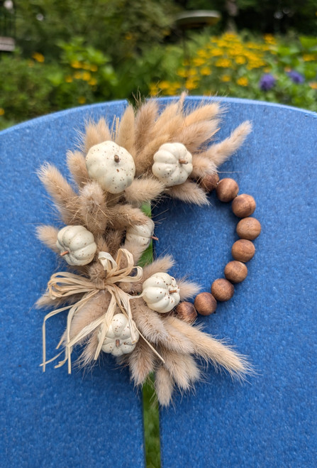 Dried bunny tail wreath accented with white pumpkins and raffia bow. Dried bunny tail wreath accented with white pumpkins and raffia bow.