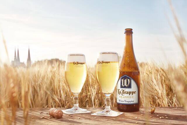 Witte trappistenbier fles met gevuld bierglas