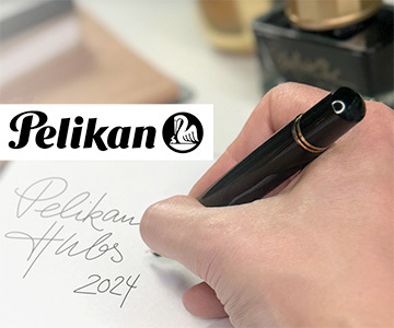 image of hand holding a Pelikan Fine Pen writing out Pelikan Hub 2024 promoting the event at the Colorado Springs store, 814 South Tejon Street in Colorado Springs on Friday, September 27, 6:30-9:30pm