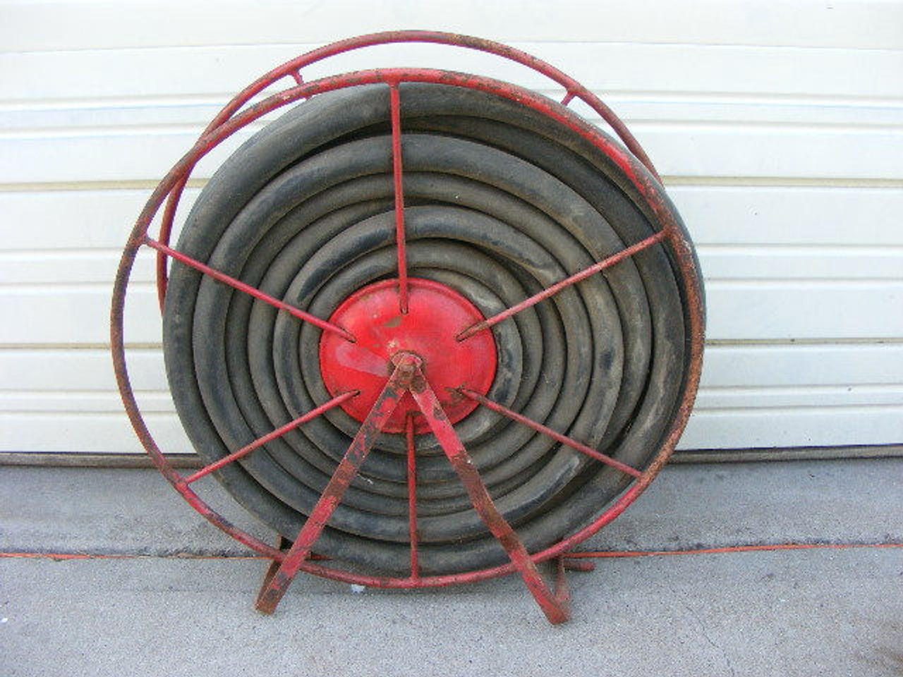 An old firefighting fire hose and reel measuring 27" x 7 1