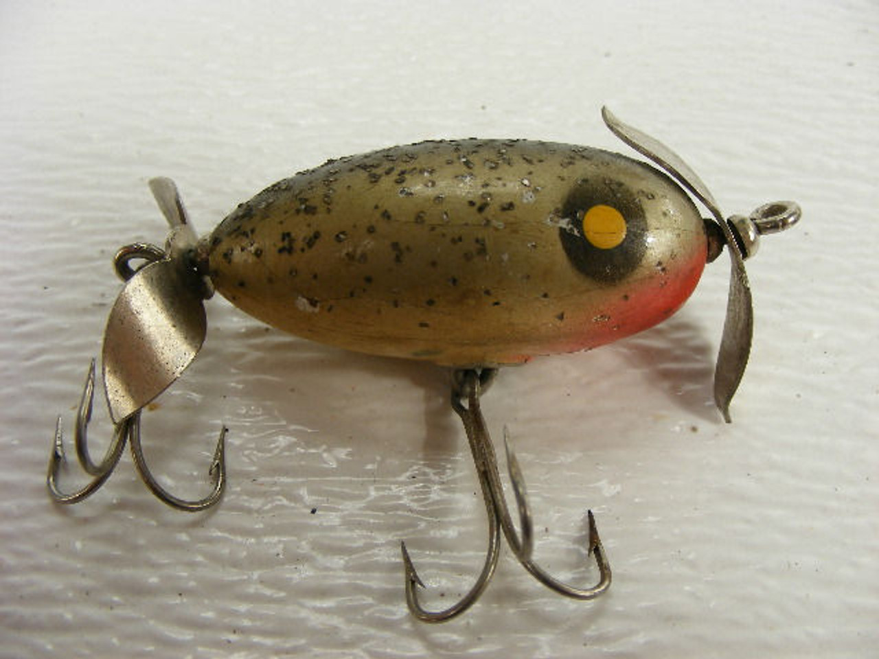 This 2 3/4 old wooden fishing lure has front and back propellors.