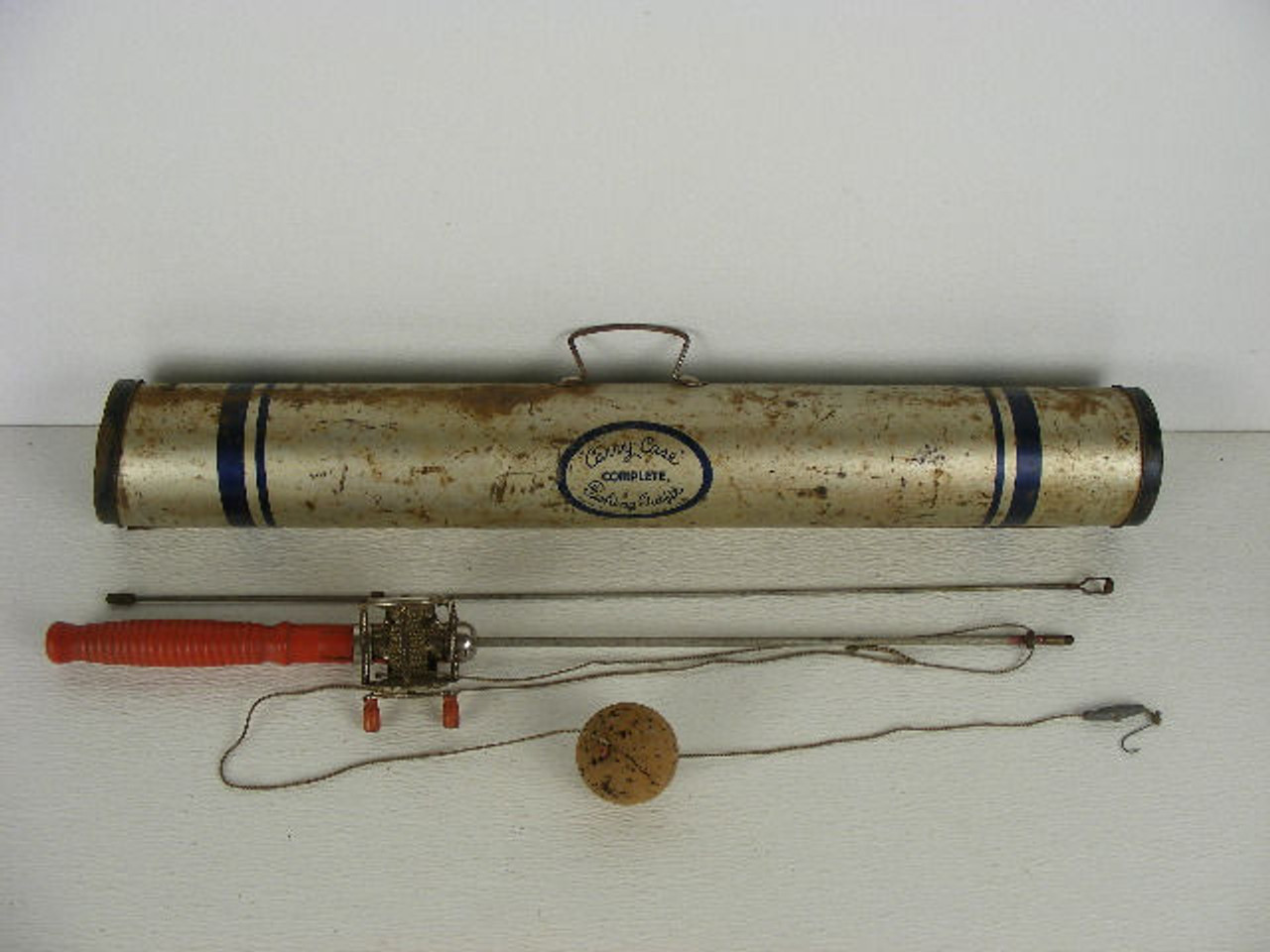This is a rare old portable breakdown fishing pole that comes in its  original metal tube.The two piece pole has a red wooden handle and threads  together measuring 45" long.The paint is