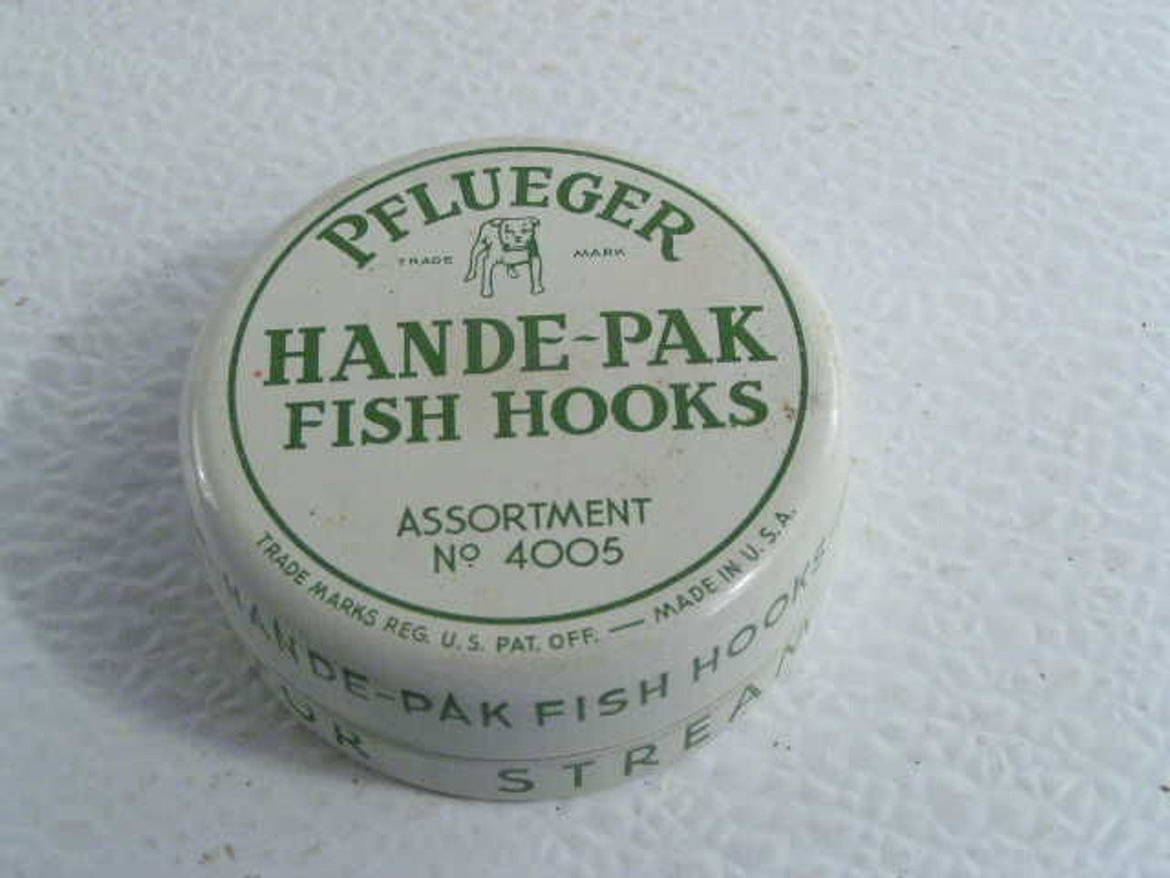 This vintage Pflueger fish hook tin #4005 with dog graphic still