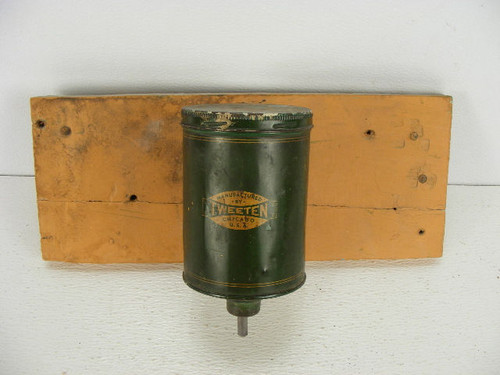 An old billiard pool table chalk dispenser marked Tweeten and mounted on a wood board.