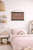 Personalized Name Canvas Wall Hanging Sign — Child's bedroom with pink bedding, rainbow decor, and a name sign on the wall