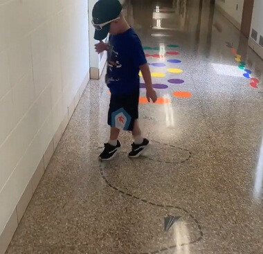 Sensory Path Tip Toe Line Paper Airplanes Sticker Decals School Hallway — Child in blue shirt walking on colorful floor