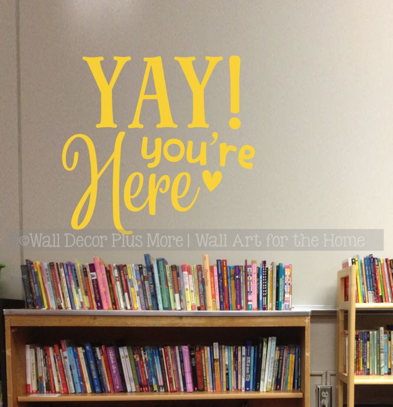 Yay You're Here welcome decal on a classroom library wall above the bookshelves