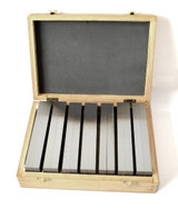 Front view of machinist parallels set in a wooden box on  a white background.