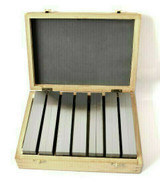 Front view of machinist parallels set in a wooden box on  a white background.