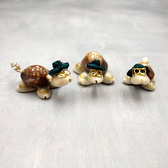 Cowrie Shell Sea Turtle Figurines Dark Green Hat (3 figures approx. 2+ inches) Cute Cowrie Seashell Sea Turtles for gifts decor & display! Copyright 2025 SeaShellSupply.com