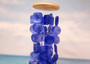Blue Capiz Round Cut Seashell Wind Chime (1 chime approx. 18 x 5 inches) Round Dark Blue Capiz Shell Wind Chime for coastal home decoration! Copyright 2025 SeaShellSupply.com.