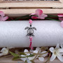 Sea Turtle Charm Bracelet Pink White Cord (approx. 5-7+ inches AROUND) Rose Carnation Sea Turtle String Bracelet Jewelry a thoughtful gift! Copyright 2025 SeaShellSupply.com.