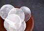 Capiz Shells - (10 shells 2 inch Round Cut). Multiple semi translucent shells in small pile. Copyright 2024 SeaShellSupply.com.