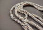 Tiger Puka Shell Strand (16 inches x 4-6mm). Multiple strands of white beaded strings. Copyright 2024 SeaShellSupply.com.