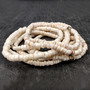 White Puka Shell Necklace - (1 necklace 18 inches x 4-5mm) on grey background. Copyright 2026 SeaShellSupply.com.
