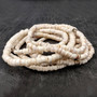 White Puka Shell Necklace - (1 necklace 18 inches x 4-5mm) on grey background. Copyright 2026 SeaShellSupply.com.\n