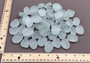 Beach Glass - Rounded Clear-White Frosted Pebbles - (approx. 1 Kilogram/2.2 lbs. 1-1.5 inches). Multiple lightly colored shells in a pile. Copyright 2022 SeaShellSupply.com.