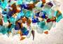 Beach Glass - Medium Tumbled Rough Brown, White & Blue Pacific Assorted - (approx. 1 Kilogram/2.2 lbs. .5-1.25 inches). Multiple blue, white, and brown fragments in a pile. All different shapes and sizes. Copyright 2025 SeaShellSupply.com.