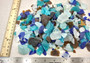 Beach Glass - Medium Tumbled Rough Brown, White & Blue Pacific Assorted - (approx. 1 Kilogram/2.2 lbs. .5-1.25 inches). Multiple blue, white, and brown fragments in a pile. All different shapes and sizes. Copyright 2025 SeaShellSupply.com.