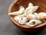 White Bullia - Bullia Annulate - (20 shells approx. 1.5 -2.5 inches). Tan spiral shells in a pile with a tight opening at the top, pretty thin shell. Copyright 2025 SeaShellSupply.com.