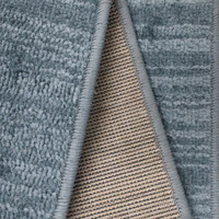 Closeup of Arlo Textured Blue Rug folded, exposing the backing.