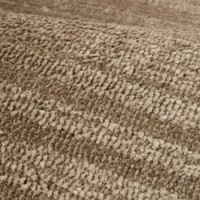 Arlo Textured Natural Rug in a living space with a seating arrangement.
