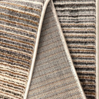 Aspre Lines Linear Rug folded, exposing the backing.