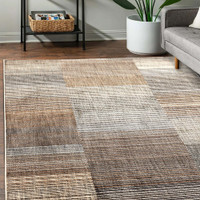 Aspre Lines Linear Rug in a living space with a seating arrangement.