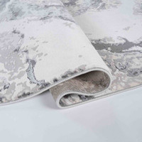 grey abstract rug folded on white floor