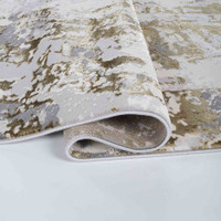 gold grey abstract rug runner folded on a white floor