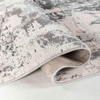 grey abstract rug runner folded on a white floor