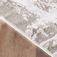 modern abstract abrasion stone rug closeup edge on a wooden floor